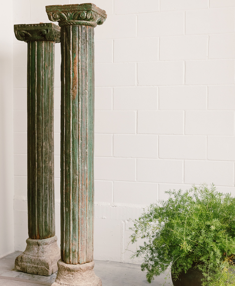 ozeano_studio dos columnas antiguas balinesas con una planta al lado